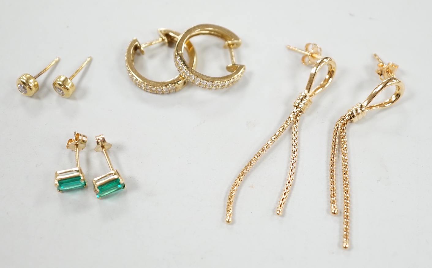 A modern pair of 18ct gold and collet set diamond ear studs, 5mm, two pairs of 9ct earrings (gross 4.5 grams) and a pair of 14k and green stone set ear studs.